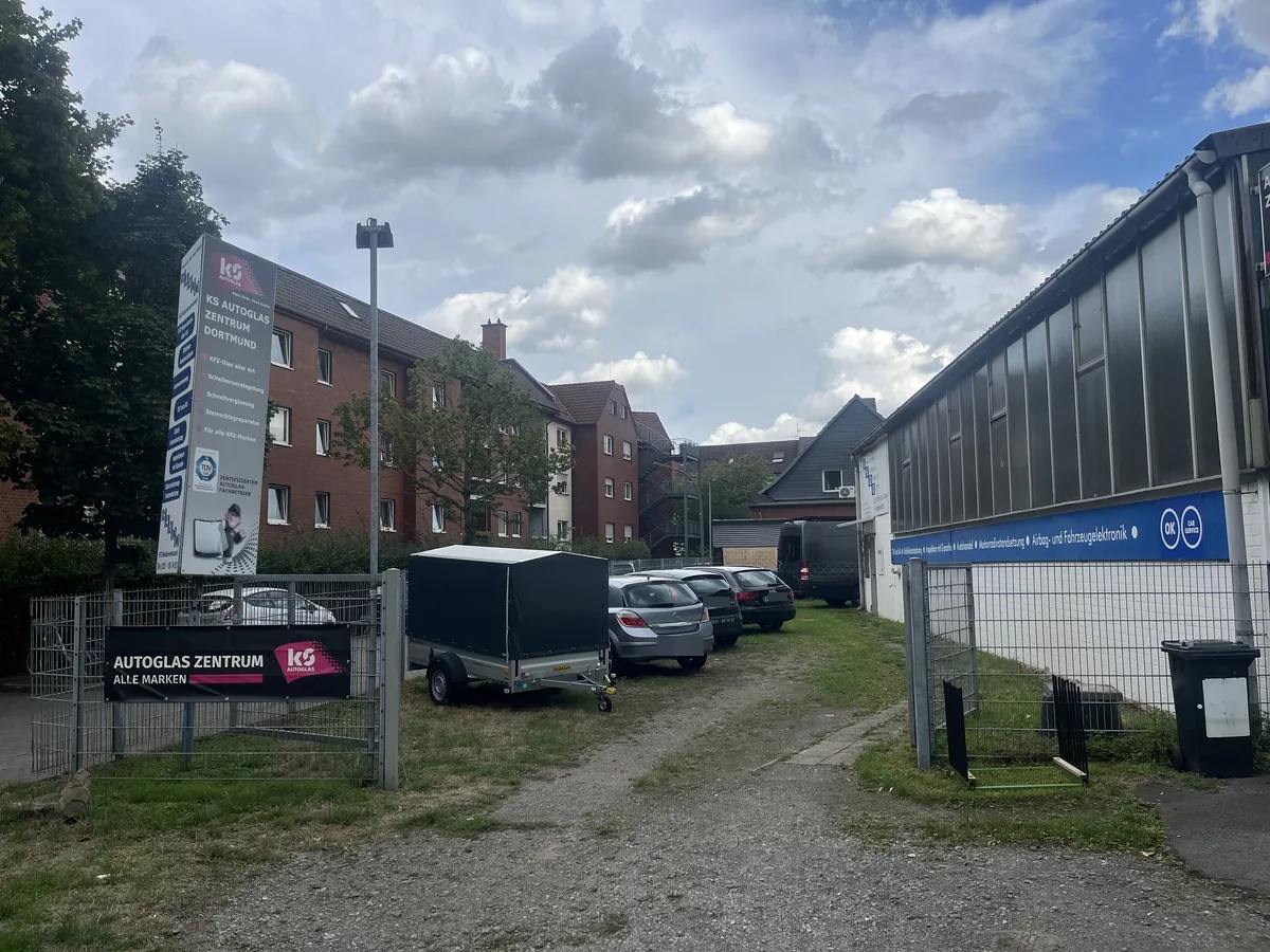 Hof der Rando Kfz Werkstatt mit Kundenfahrzeugen und Anhänger